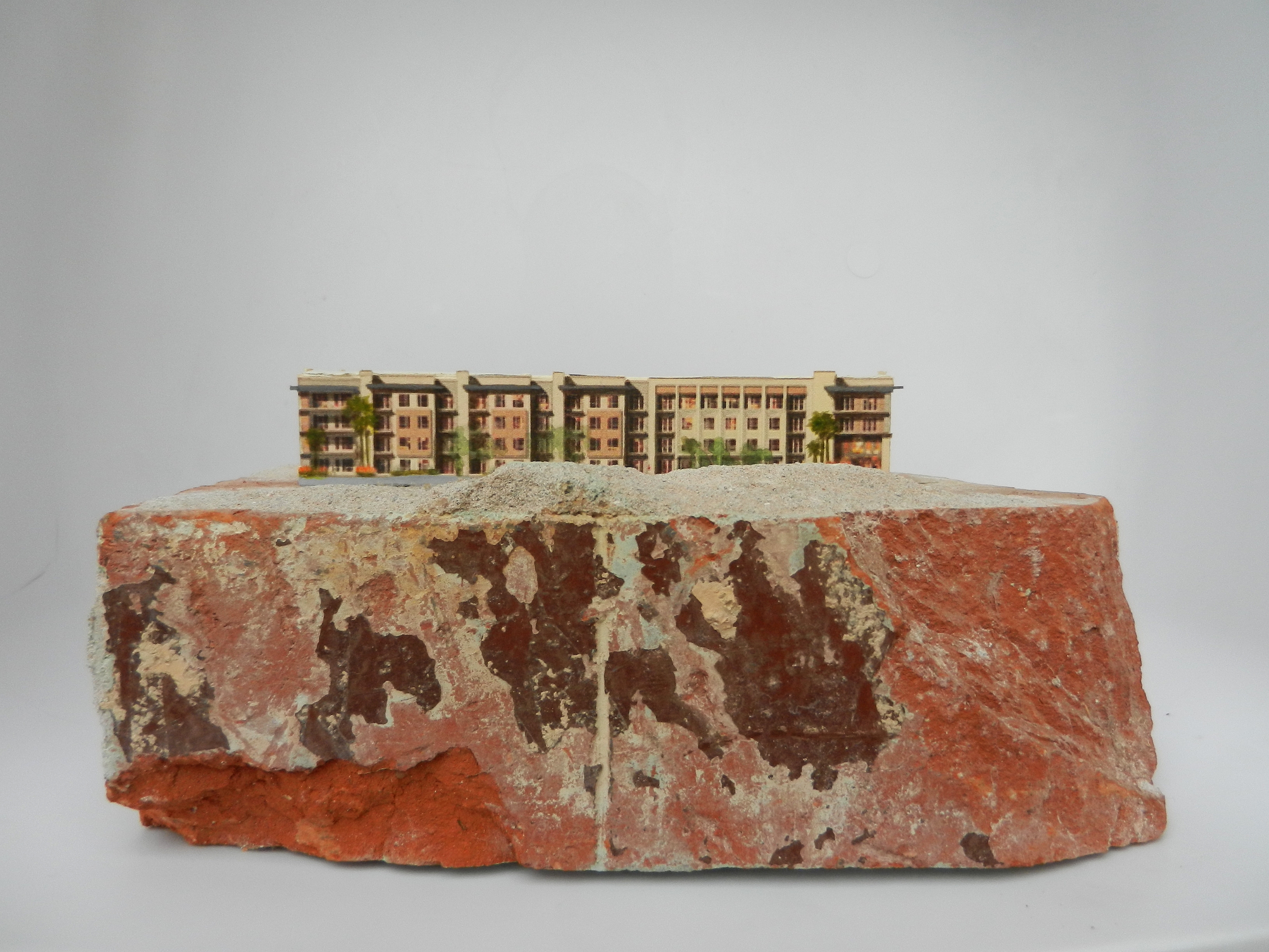 Mixed media artwork by Judith Dauncey, generic paper condo "installed" on a salvaged brick from the historic 307 club in downtown Phx